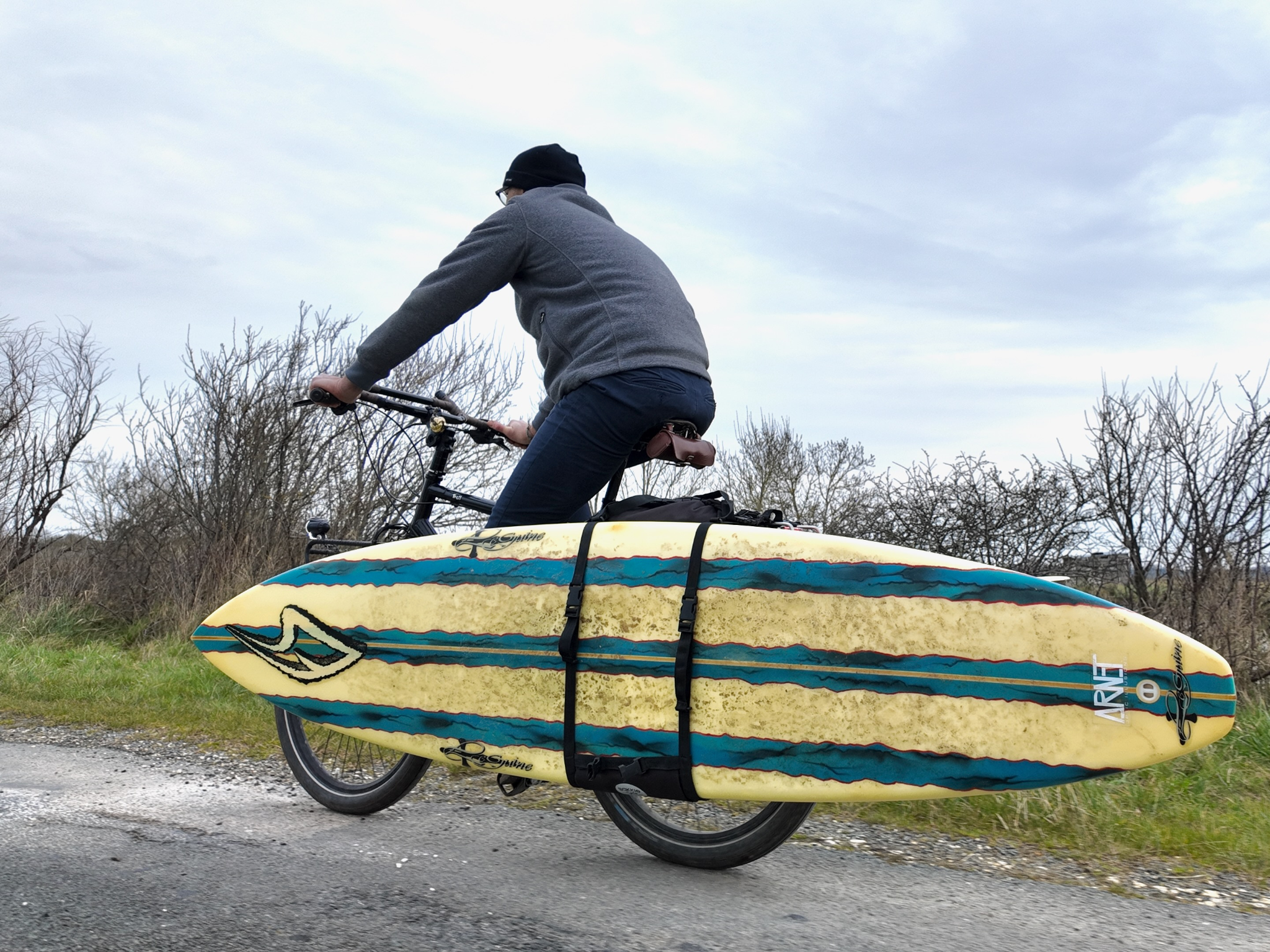 Ein Surfbrett auf dem Fahrrad transportieren mit den Fahrradtaschen von Bakkie Cycles